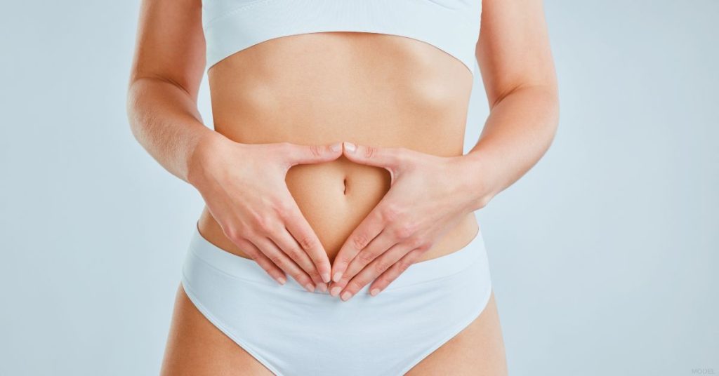 a person with their hands on their stomach (model)