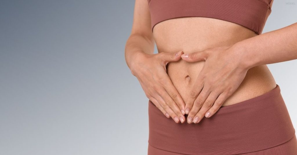 Woman with her hands on the stomach (MODEL)